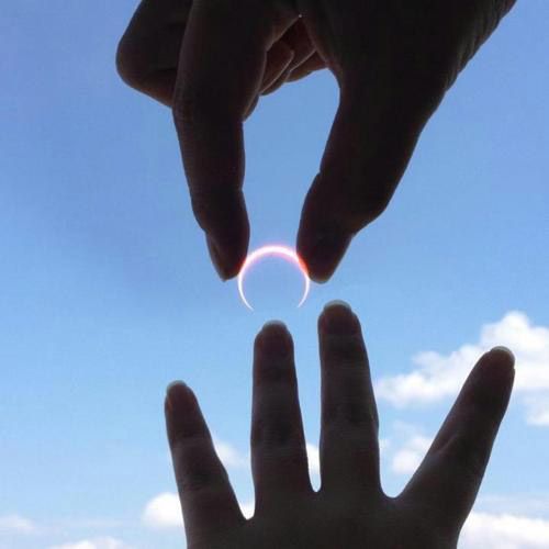 Will you marry me? Bella's hand reaches towards the sky. Above her ring finger burns the fiery ring of the eclipsed sun. Edward places his fingers around it to offer it as a wedding proposal.